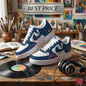 A pair of custom blue and white sneakers on a wooden art studio desk with art supplies and a vinyl record.