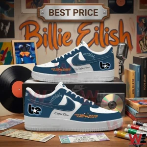 Custom blue and white sneakers with orange swooshes on a table with concert memorabilia and music items.