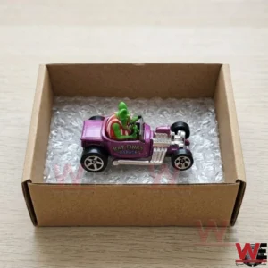 Purple Rat Fink hot rod toy car in a cardboard box.