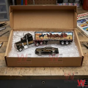 Black semi-truck with Western trailer and Pontiac Firebird Trans Am die-cast cars in box