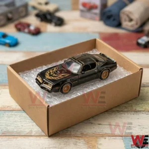 Black and gold 1977 Pontiac Firebird Trans Am diecast model car in packaging