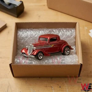Vintage red die-cast collectible car toy in a shipping box