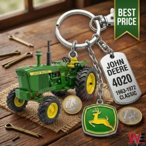 A green tractor keychain with a deer logo and a metal tag on wood!