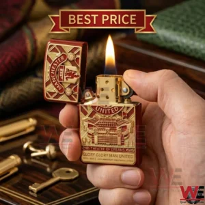 A brass Manchester United commemorative zippo style lighter with club iconography and flame lit.