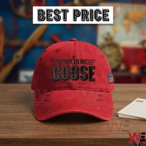 Red baseball cap with black talk to me goose embroidery on a wooden desk with a notebook!