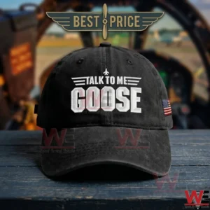 Black baseball cap with white talk to me goose text on a blue wooden table in front of a cockpit!