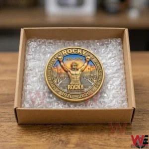 A golden Rocky movie anniversary coin packed in a cardboard box with bubble wrap.