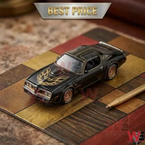 Black and gold 1977 Pontiac Trans Am die-cast model car on a patterned desk mat.